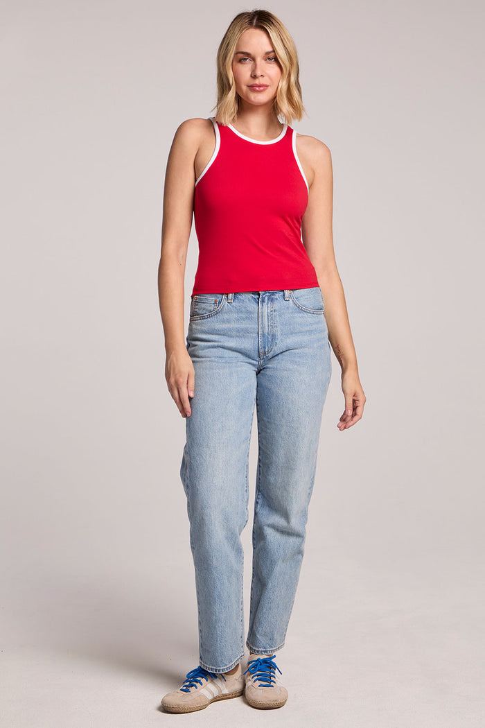 A full body front view of a woman wearing the Chaser Lisbon Cardinal Red Tank and sneakers on a neutral background