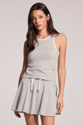 A front view of a woman wearing the Chaser Heather Grey Lisbon Tank and matching skort on a neutral background