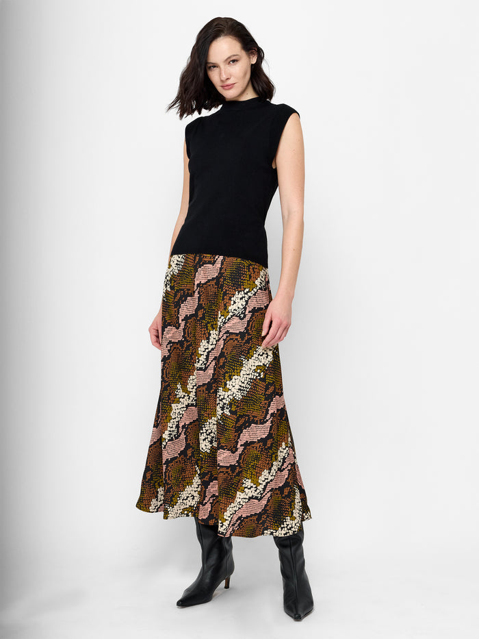 A woman wearing a snakeskin maxi skirt with an elastic waistband and a maxi length.