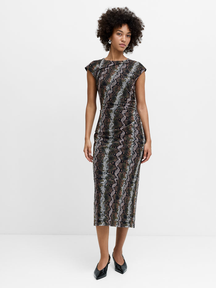A woman wearing a snakeskin mesh midi length dress with a ruched waist, cap sleeves and a boat neckline.