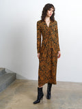 Woman wearing a textured front twist collared midi dress in an orange and black abstract print