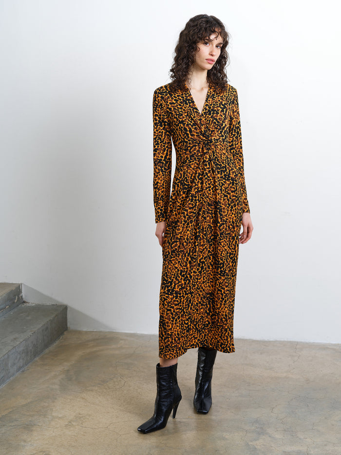 Woman wearing a textured front twist collared midi dress in an orange and black abstract print