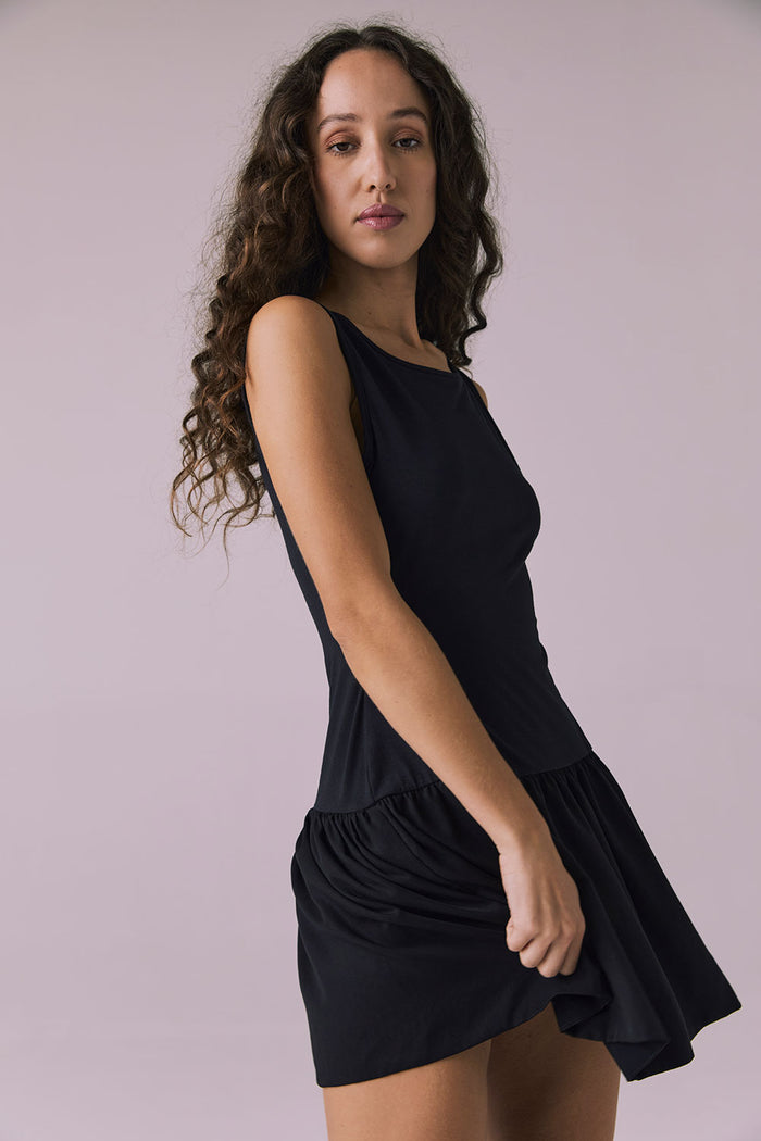 Side view of Chaser Brand Lou Licorice Black Mini Dress emphasizing flowy mini hem and relaxed shape