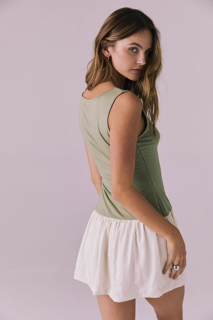 Back angle view of Chaser Brand Lou Meadow Green Mini Dress showing subtle waist shaping and airy off white skirt