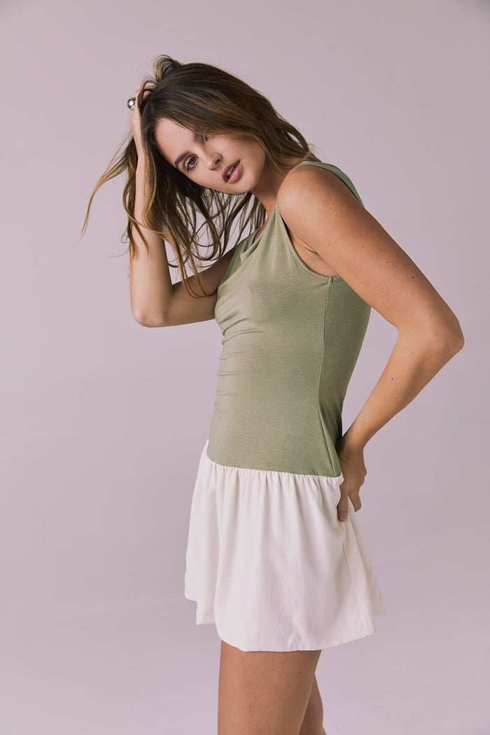Side angle of Chaser Brand Lou Meadow Green Mini Dress emphasizing the curve hugging bodice and floaty mini hem