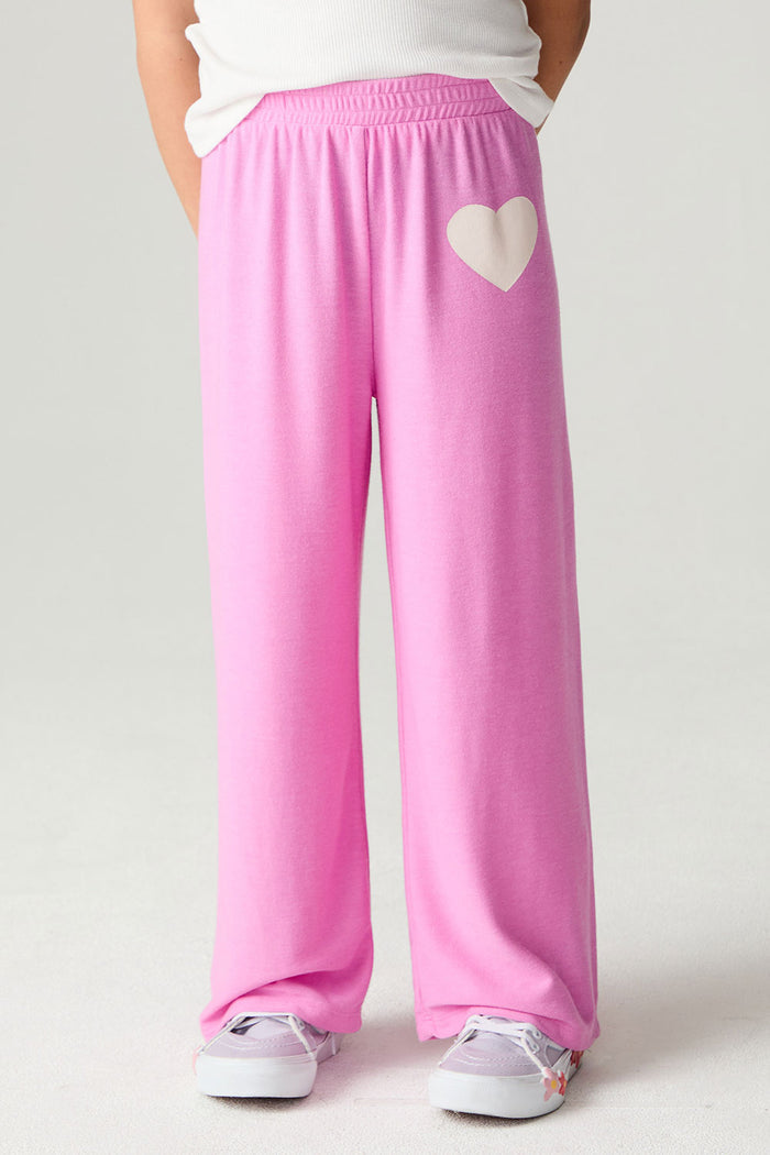 Front view of a girl wearing the Chaser Love Is Everywhere Girls Pants Jogger with white tee shirt
