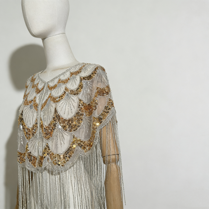 Luxury handcrafted bridal capelet with shimmering sequins, bead embroidery and flowing fringe in elegant ivory.