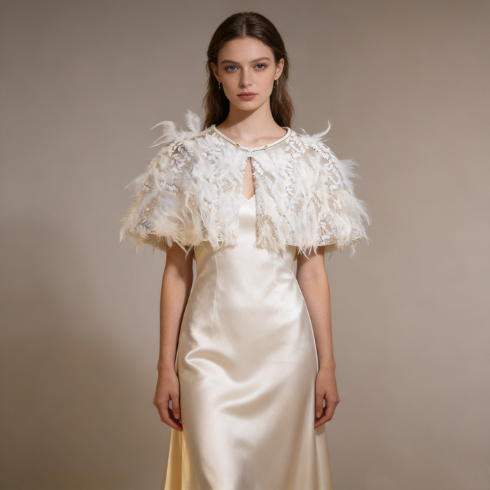 Handcrafted bridal shoulder cape with botanical embroidery, airy feathers and romantic couture styling.
