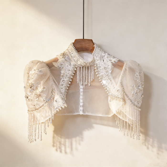 Luxury bridal capelet with high neckline, hand embroidered tulle, pearls, crystals and sparkling crystal fringe.