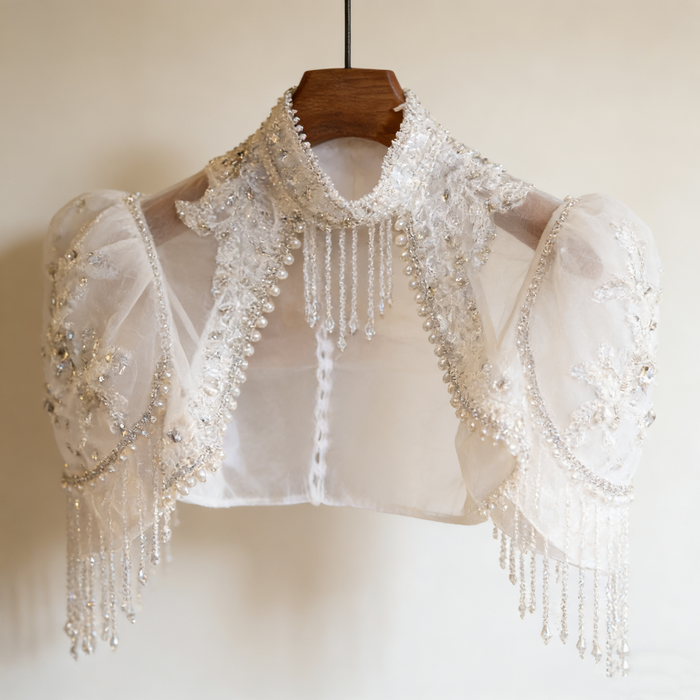 Luxury bridal capelet with high neckline, hand embroidered tulle, pearls, crystals and sparkling crystal fringe.