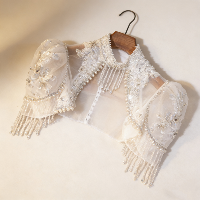 Luxury bridal capelet with high neckline, hand embroidered tulle, pearls, crystals and sparkling crystal fringe.