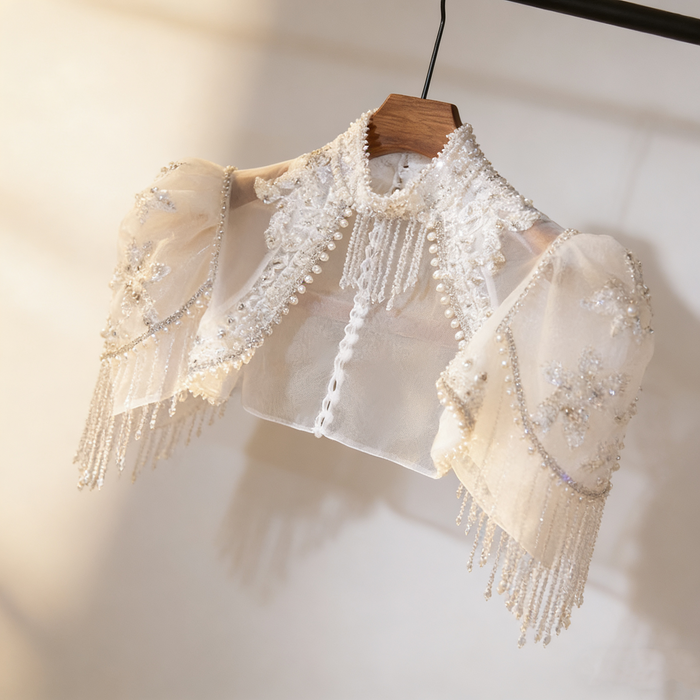 Luxury bridal capelet with high neckline, hand embroidered tulle, pearls, crystals and sparkling crystal fringe.