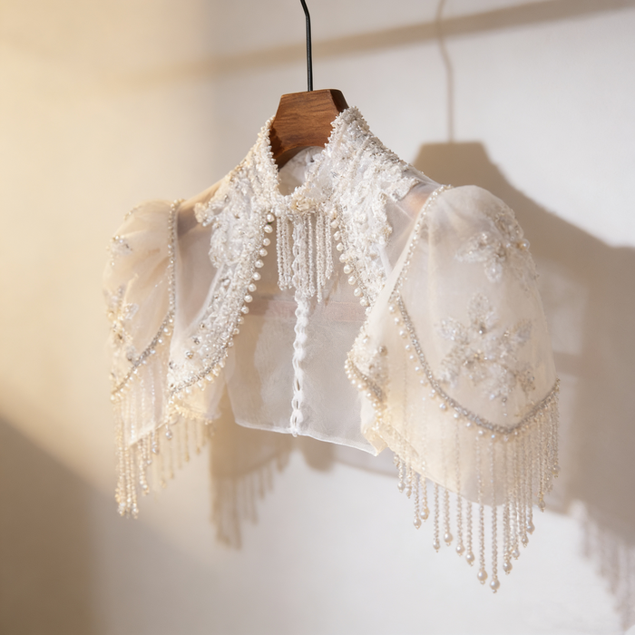 Luxury bridal capelet with high neckline, hand embroidered tulle, pearls, crystals and sparkling crystal fringe.
