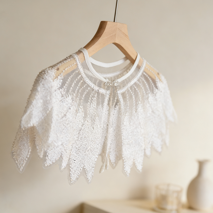 Luxury Swan Lake inspired ivory bridal capelet with illusion tulle and hand-embroidered sequin feather motifs.