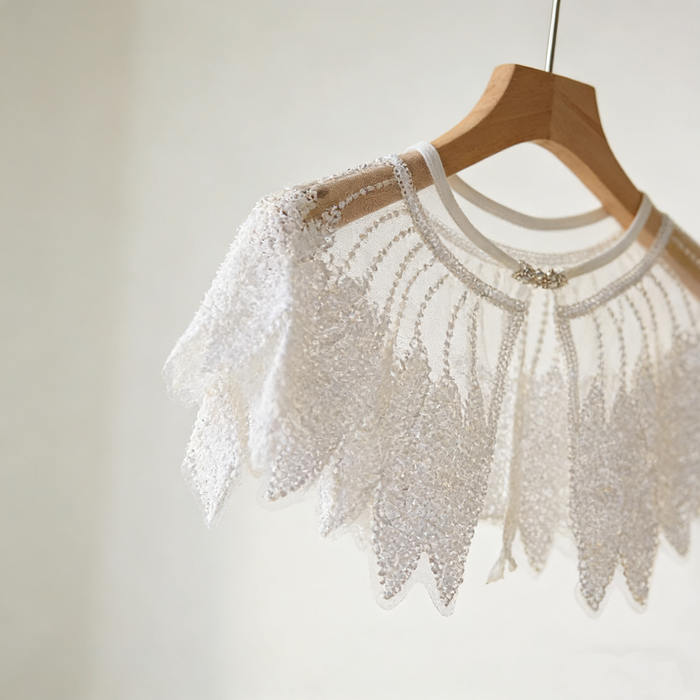 Luxury Swan Lake inspired ivory bridal capelet with illusion tulle and hand-embroidered sequin feather motifs.