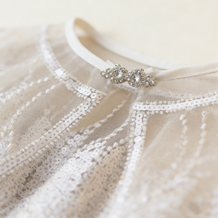 Luxury Swan Lake inspired ivory bridal capelet with illusion tulle and hand-embroidered sequin feather motifs.
