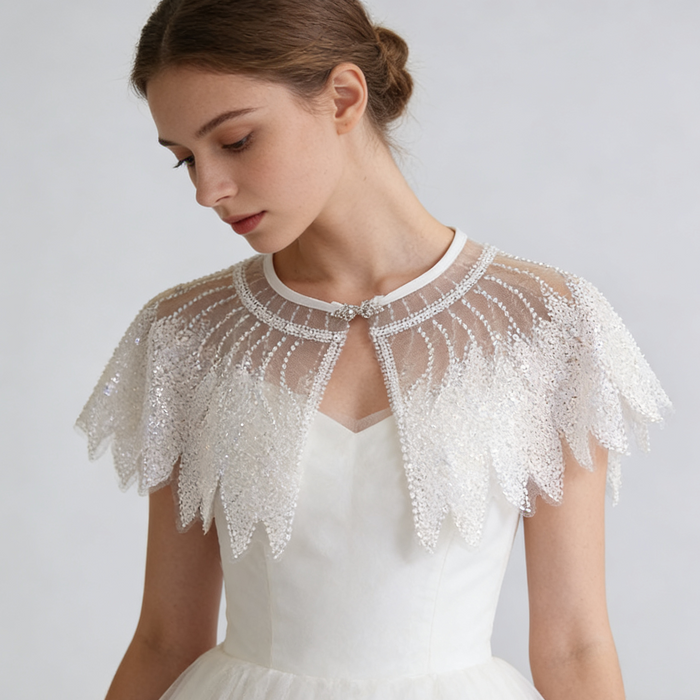 Luxury Swan Lake inspired ivory bridal capelet with illusion tulle and hand-embroidered sequin feather motifs.