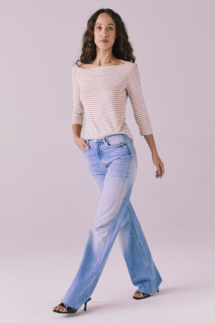 Full body walking view of Chaser Brand Malynne Khaki Stripe Tee paired with wide-leg denim and heels
