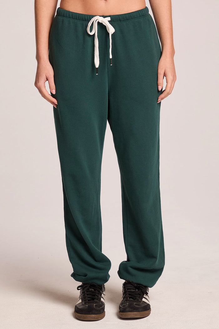 Front view of a woman wearing the Chaser   Manhattan Pine Joggers on a neutral background with hands at her sides