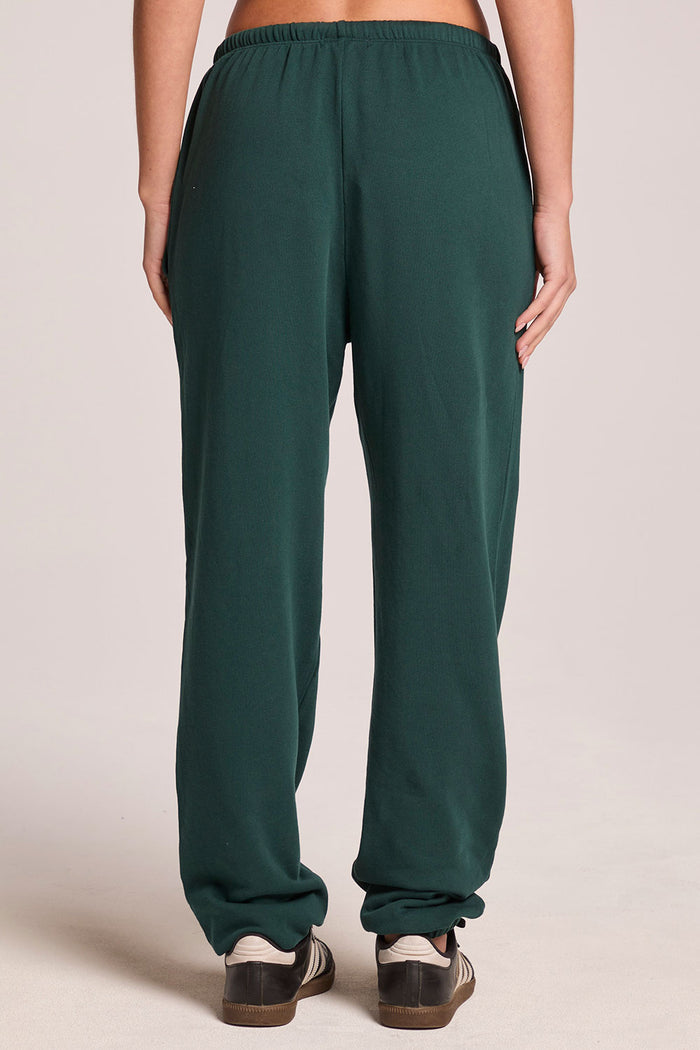 Back view of a woman wearing the Chaser   Manhattan Pine Joggers on a neutral background