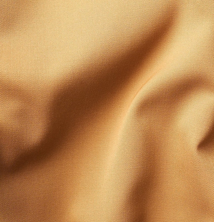 Close-up of marigold tuxedo fabric with folds, showing woven texture