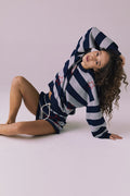 Seated view of Chaser Brand Maritime Stars Shorts in Heather Grey Stripe styled with the matching Maritime Stars Pullover
