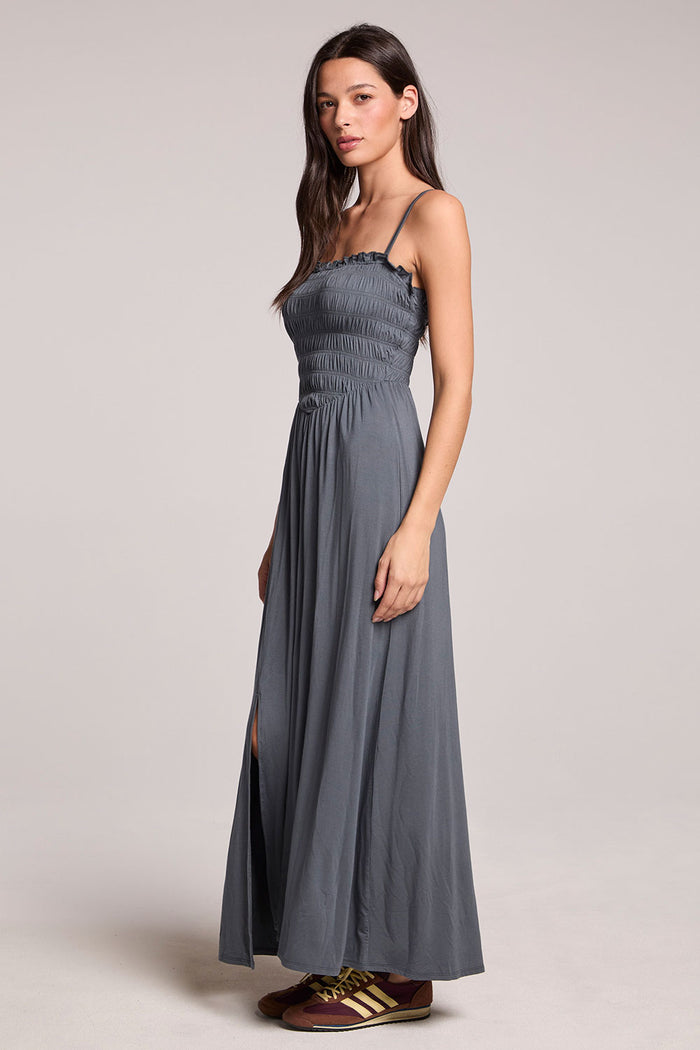 Side angle view of a woman wearing the Chaser Future Grey Marquise Dress on a neutral background with brown shoes