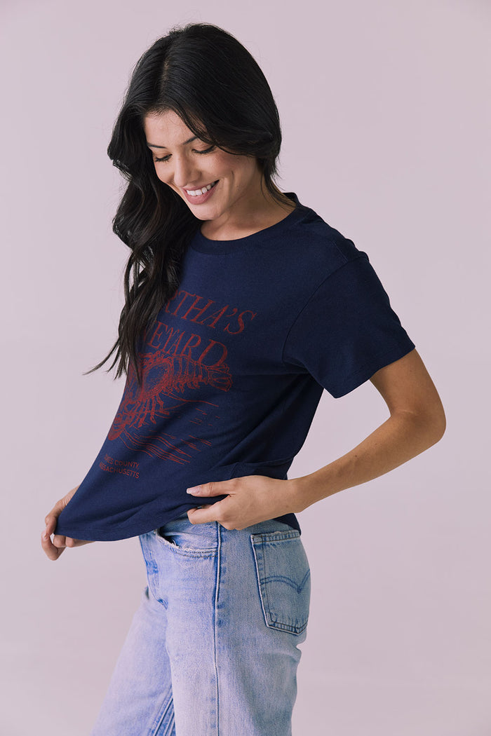 Front angled view of Chaser Brand Martha’s Vineyard Tee in Navy with model looking down showcasing lived-in texture and graphic detail