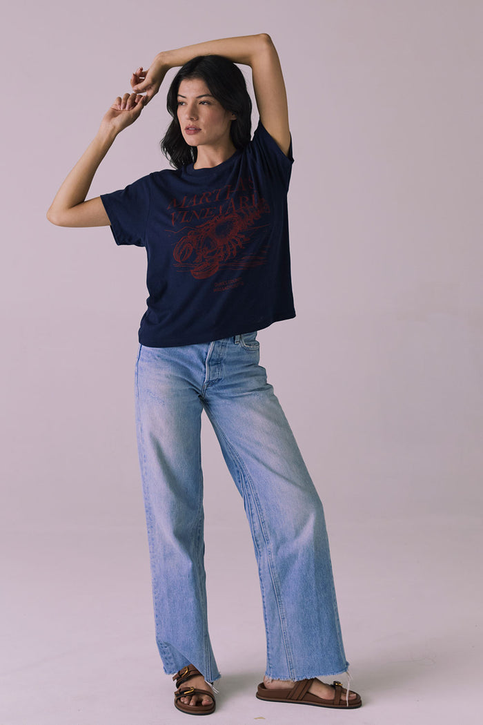 Full body view of Chaser Brand Martha’s Vineyard Tee in Navy styled with light wash jeans and sandals for a coastal-casual look
