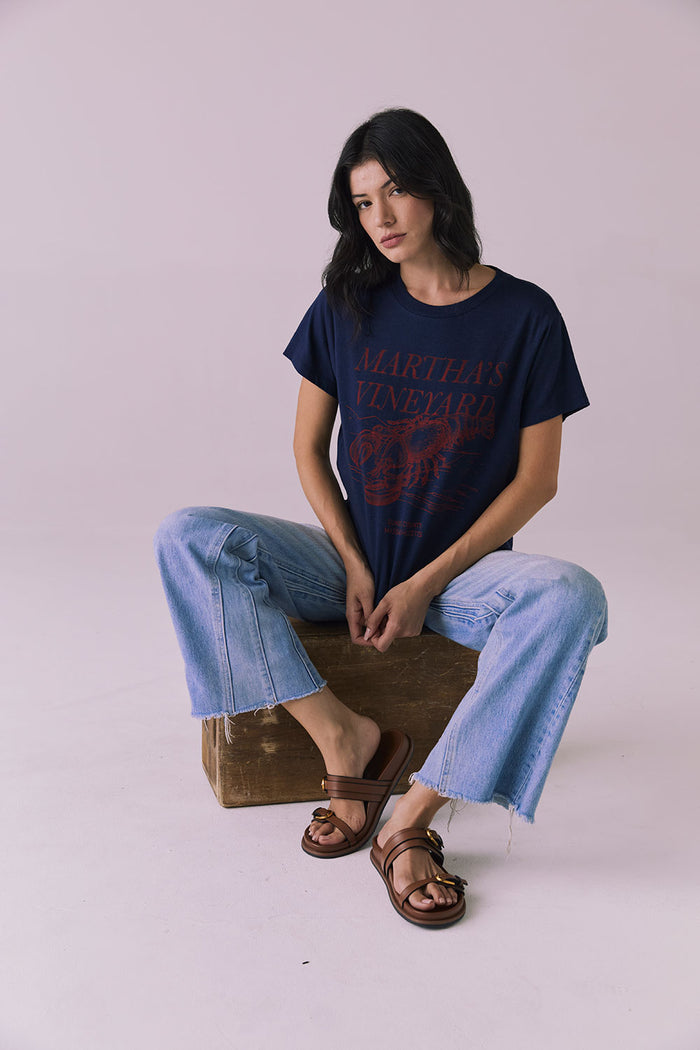Seated editorial view of Chaser Brand Martha’s Vineyard Tee in Navy capturing slouchy fit and vintage-inspired print