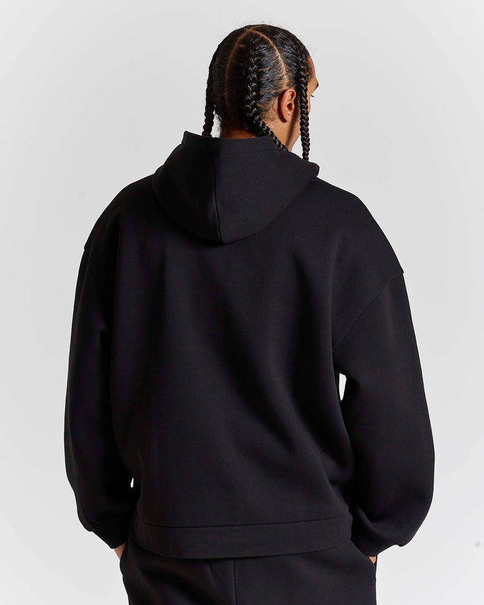 Displays a model wearing the Black 'Hoodrich' branded men's Aegis Full Tracksuit