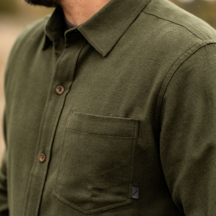 Man in Pladra Men's Cascade Flannel Shirt - Olive Green, shown from shoulders to mid-chest.