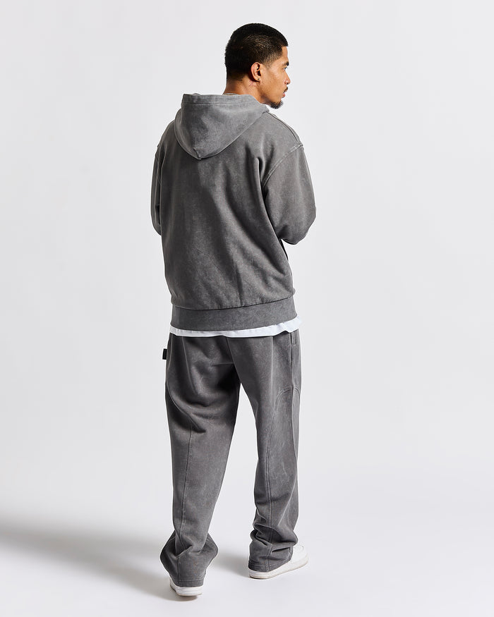 A man wearing a gray hooded sweatshirt and matching gray sweatpants, shown from the back against a light gray studio background.