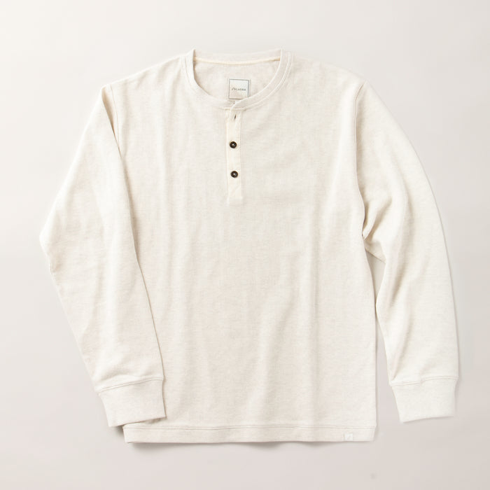 The Men's Elko Henley in Oatmeal White is a light beige, long-sleeve cotton shirt featuring a round neckline and three dark buttons, displayed flat on a plain light background.