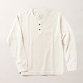 The Men's Elko Henley in Oatmeal White is a light beige, long-sleeve cotton shirt featuring a round neckline and three dark buttons, displayed flat on a plain light background.