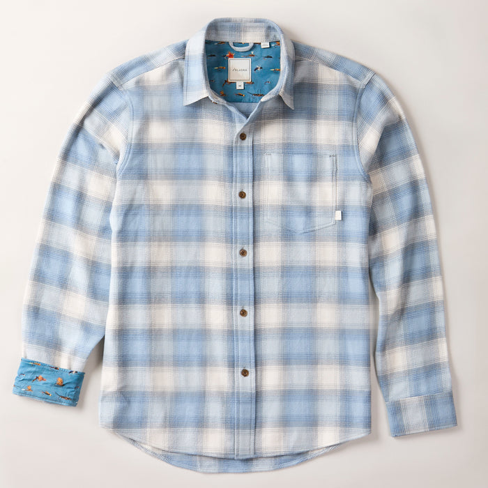 The Men's Every Day Elite Flannel Shirt- Mendocino Blue is a heavyweight Portuguese flannel, long-sleeve button-up with light blue and white plaid, brown buttons, front pocket, and blue fish-print fabric inside the collar and cuffs.