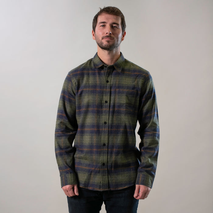 A man stands against a plain light background, wearing the Men's Every Day Flannel Shirt- Everett Green Heather with dark pants. He faces forward with a neutral expression and his arms relaxed at his sides.