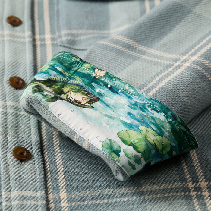 The Pladra Men's Fireside Flannel in Island Blue features rolled cuffs revealing a colorful fish and lily pad lining.