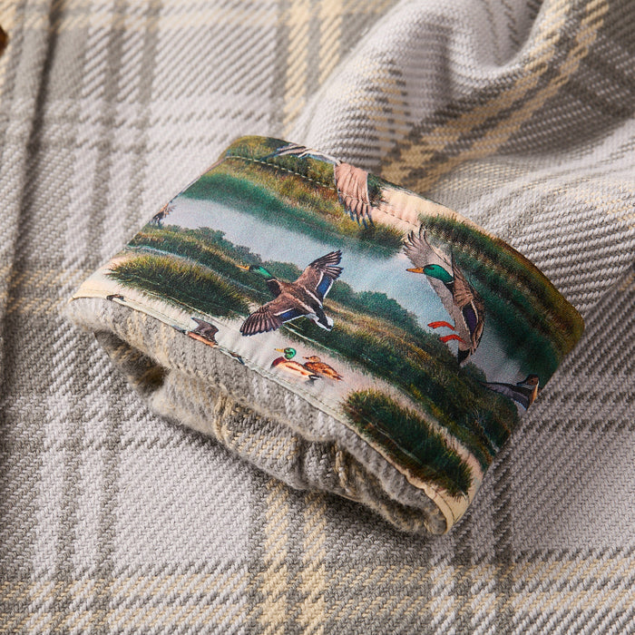 A close-up of the Men's Fireside Flannel - Quartz Grey sleeve cuff in soft organic cotton, featuring flying ducks and marshland inside, contrasted by its gray and beige check plaid.