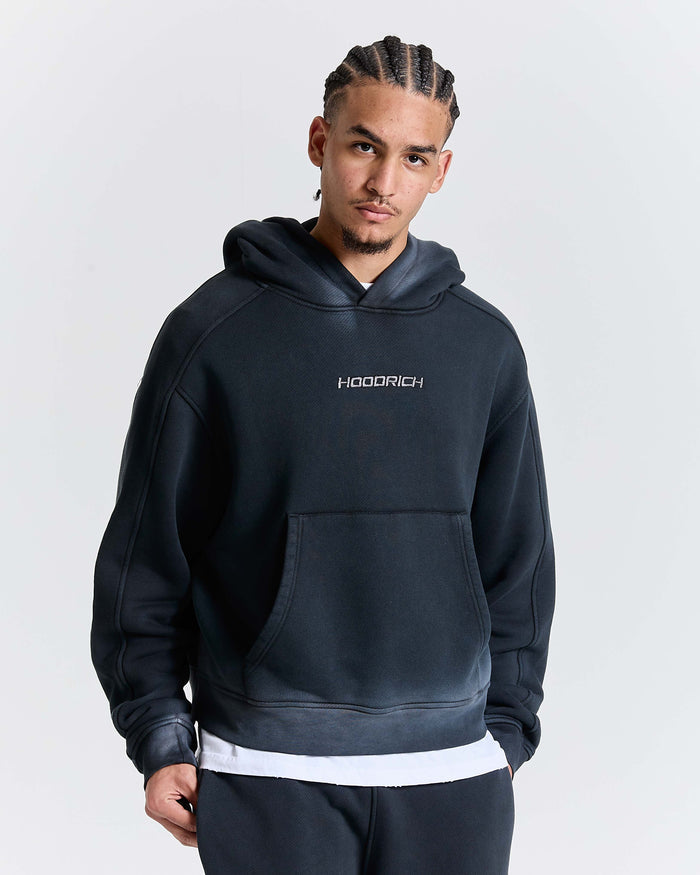 Male model wearing an oversized black Hoodrich hoodie with a kangaroo pocket.