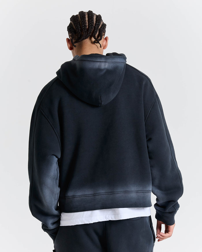 Rear view of a person wearing a black hoodie with a plain background