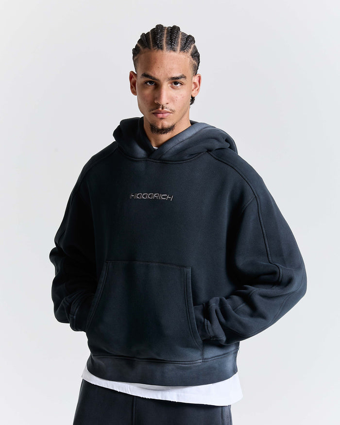 Person wearing a black hoodie with a HOODRICH brand logo on a white background