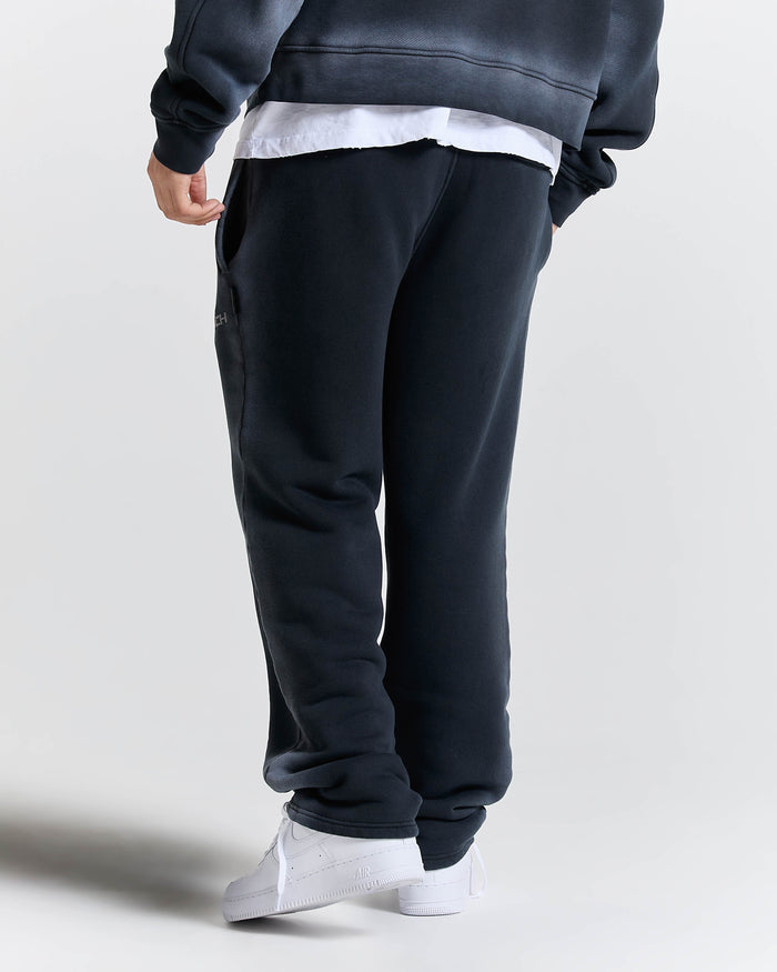 Person wearing navy blue sweatpants on a plain background