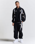 Male model wearing a black tracksuit with white accents on a light gray background