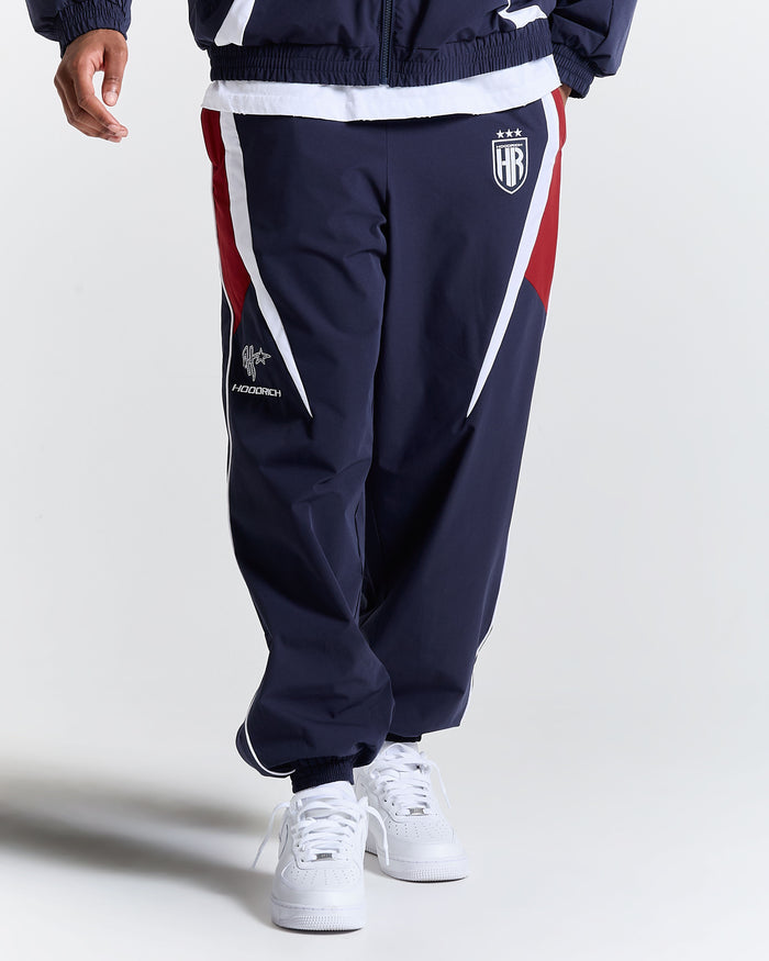 Navy tracksuit with red and white accents on a plain background