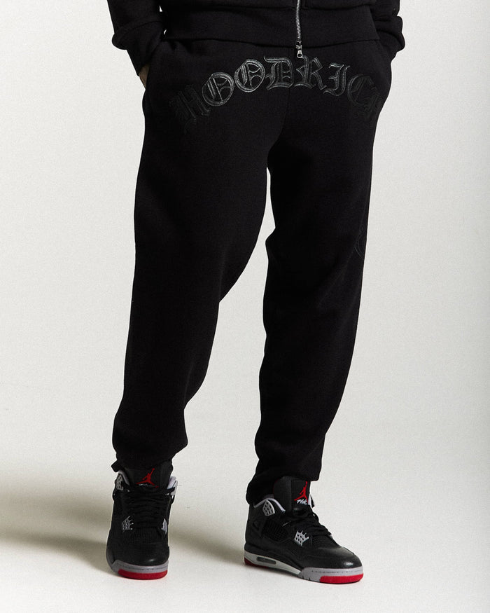 Black jogger pants with brand logo on a white background