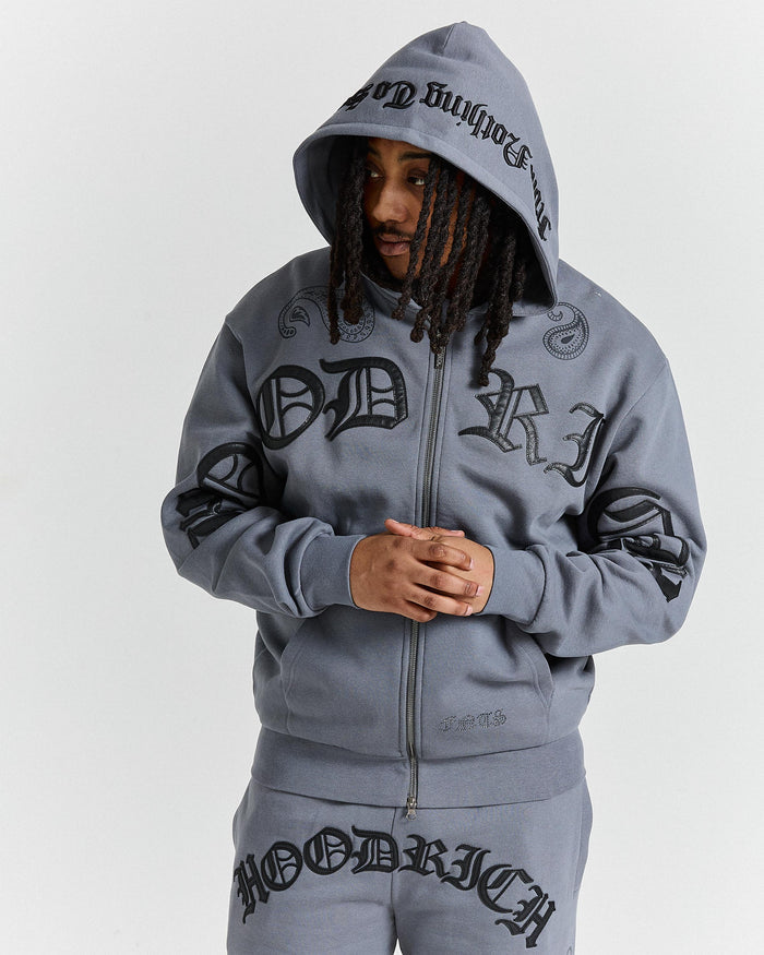 Person wearing a gray hoodie with branding on a white background