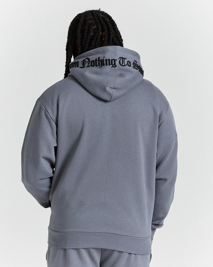 Person wearing a gray hoodie with text on the back against a white background