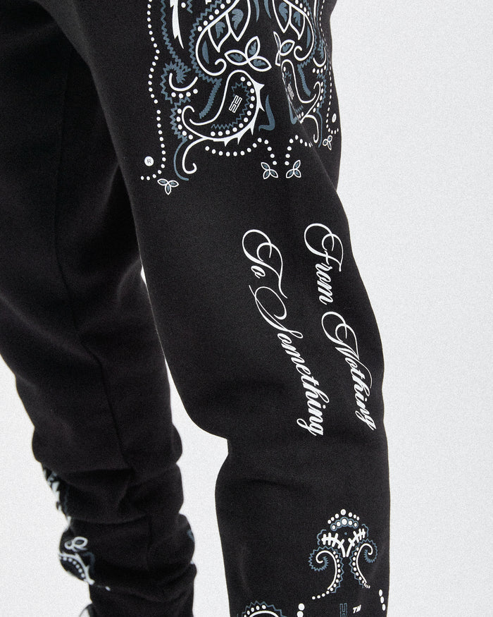 Displays a model wearing the black 'hoodrich' branded men's Motif Full Tracksuit