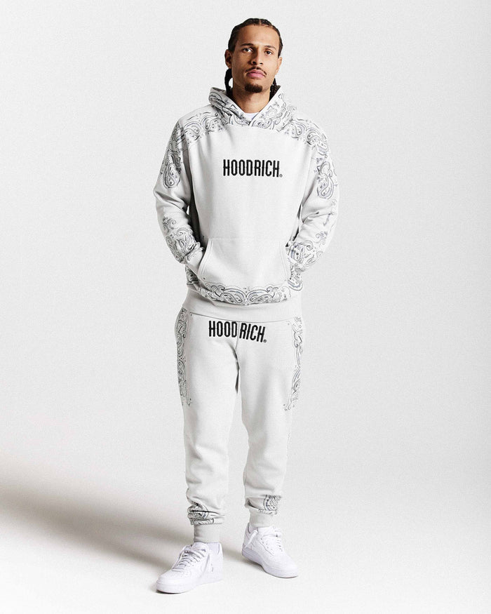 Person wearing a white 'Hoodrich' tracksuit on a light gray background